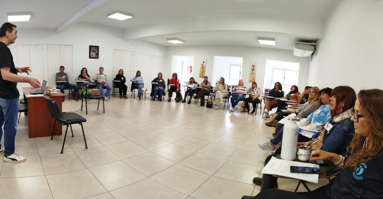 Clase presencial con participantes sentados en semicírculo